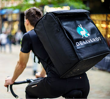 Leeds, UK - October 14, 2017: Deliveroo driver is riding in Leeds streets, Saturdays are busiest day in week for Delivery 