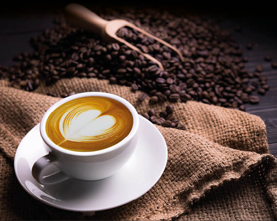 Cup of coffee latte with heart shape and coffee beans on old wooden background