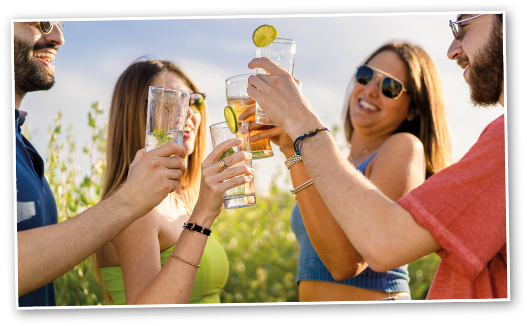 Friends toast at outdoors party  Young people toasting with cocktails at the garden 