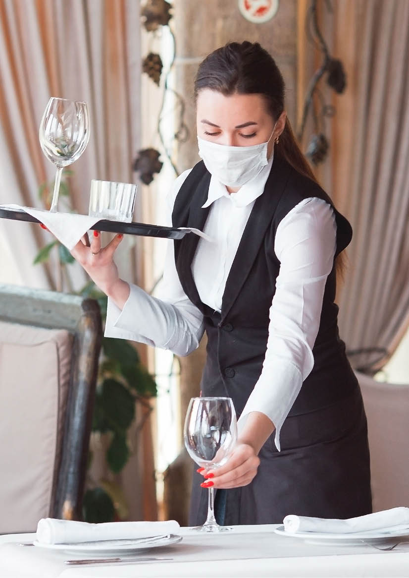 work of a waiter in a restaurant in a medical mask