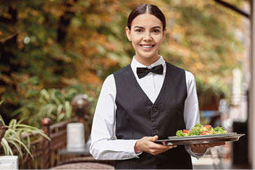 Young waitress with salad in restaurant