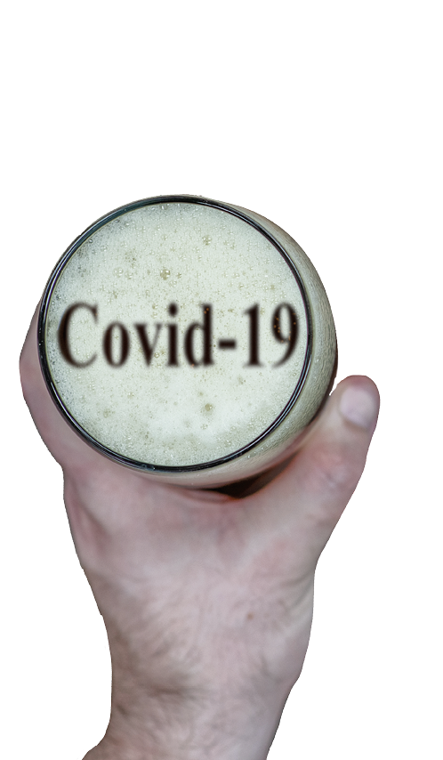 Mans hand holds a glass with beer  inscription on the foam  covid-19   Top down view 
