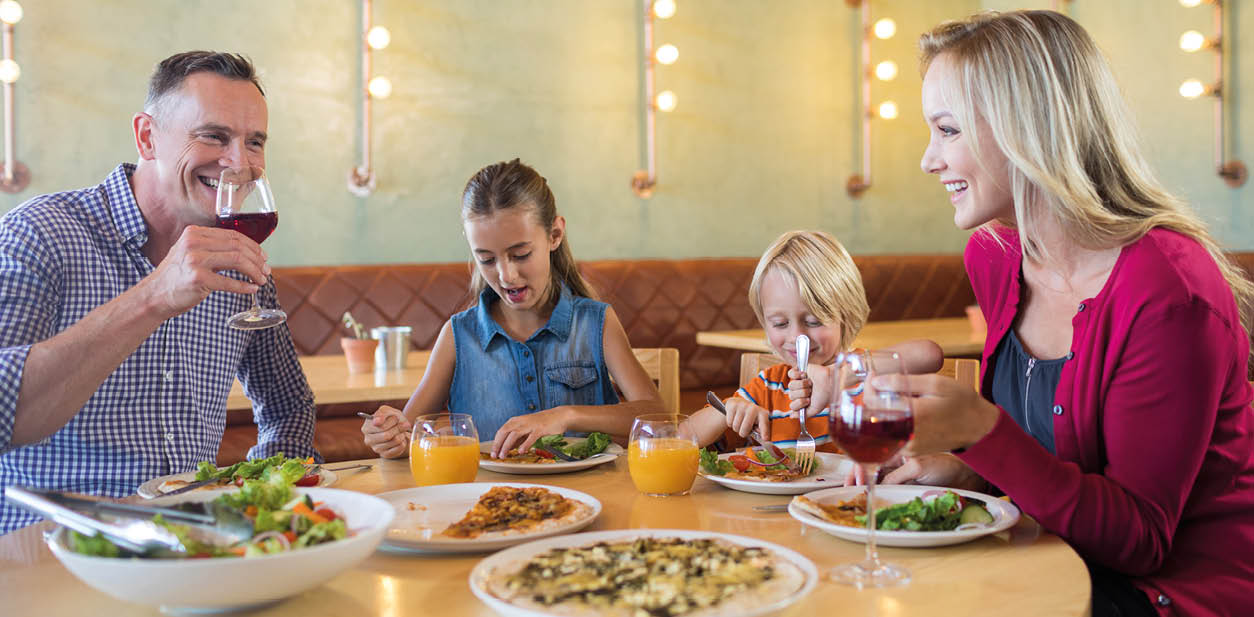 Happy family talking while having dinner at restaurant