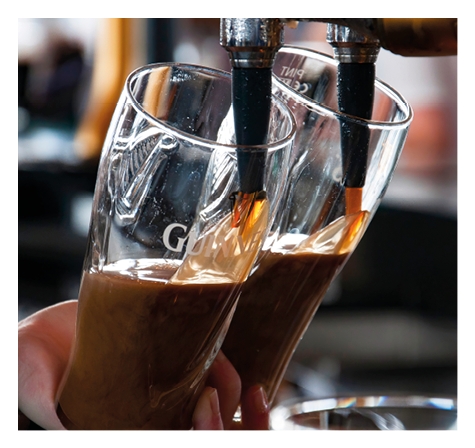 DUBLIN, IRELAND - MAY 26, 2013: Two pints of Guinness being poured in the Guinness storehouse gravity bar.