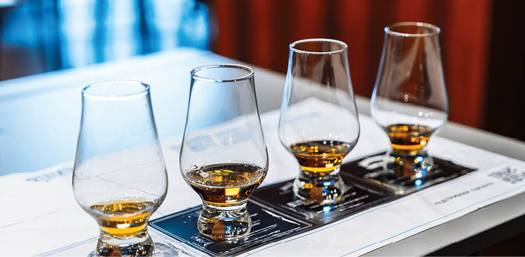 Enjoying whiskey tasting with four glasses and tasting notes on a table