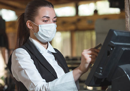 work of a waiter in a restaurant in a medical mask