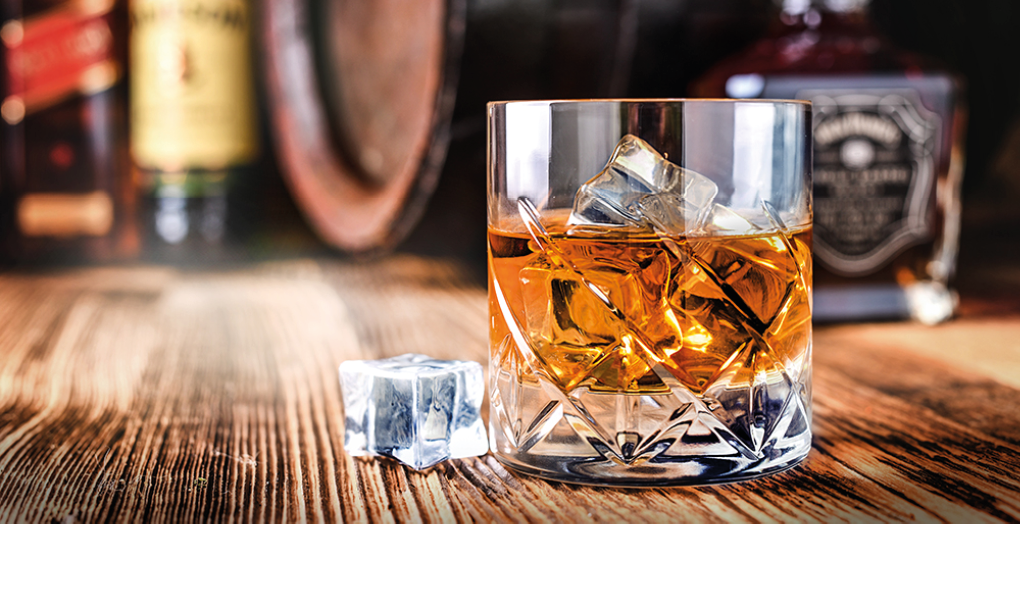 Glass of whiskey with ice cubes on black stone table  Side view with copy space alcohol concept 