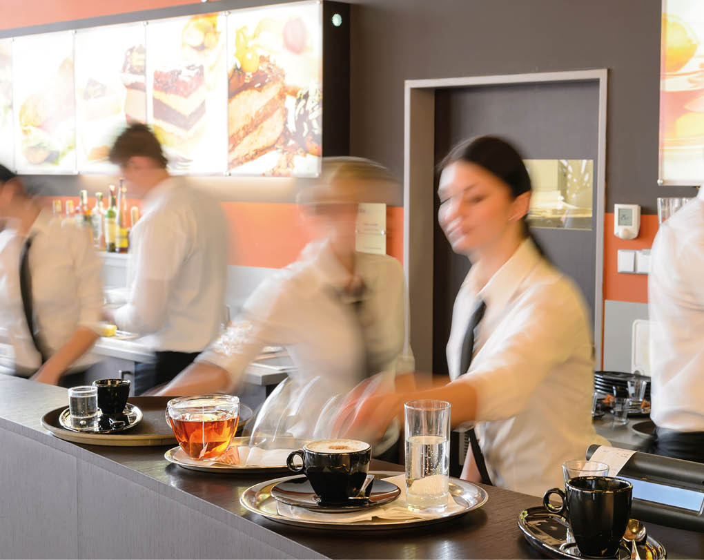 Busy waiter and waitresses working at bar night