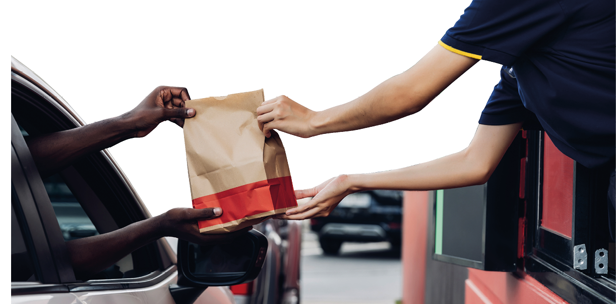 Hand Man in car receiving coffee in drive thru fast food restaurant. Staff serving takeaway order for driver in delivery window. Drive through and takeaway for buy fast food for protect covid19.