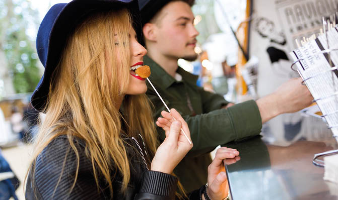 Portrait of beautiful young couple visiting eat market in the street 