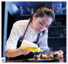 Chef dressing prepared meal