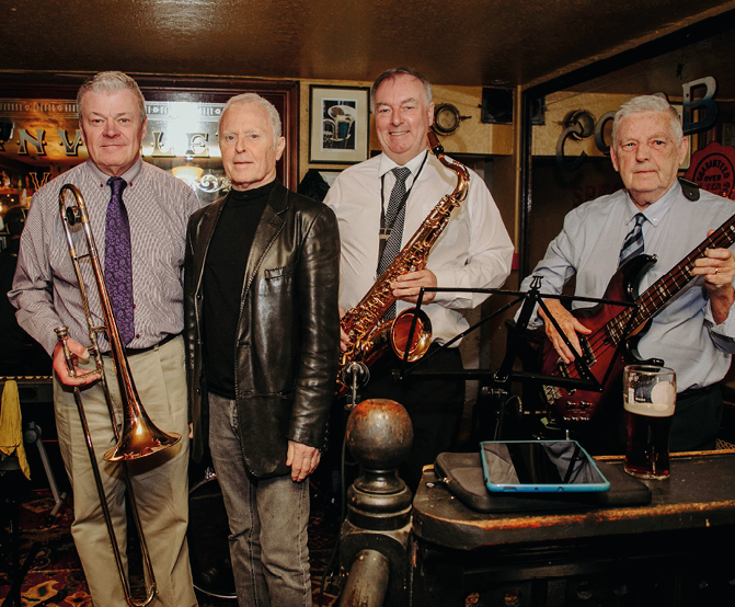 A group of men posing with musical instruments Description automatically generated