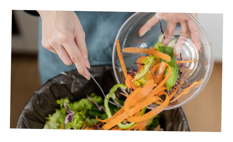 Compost the kitchen waste, recycling, organic meal asian young household woman scraping, throwing food leftovers into the garbage, trash bin from vegetable. Environmentally responsible, ecology.