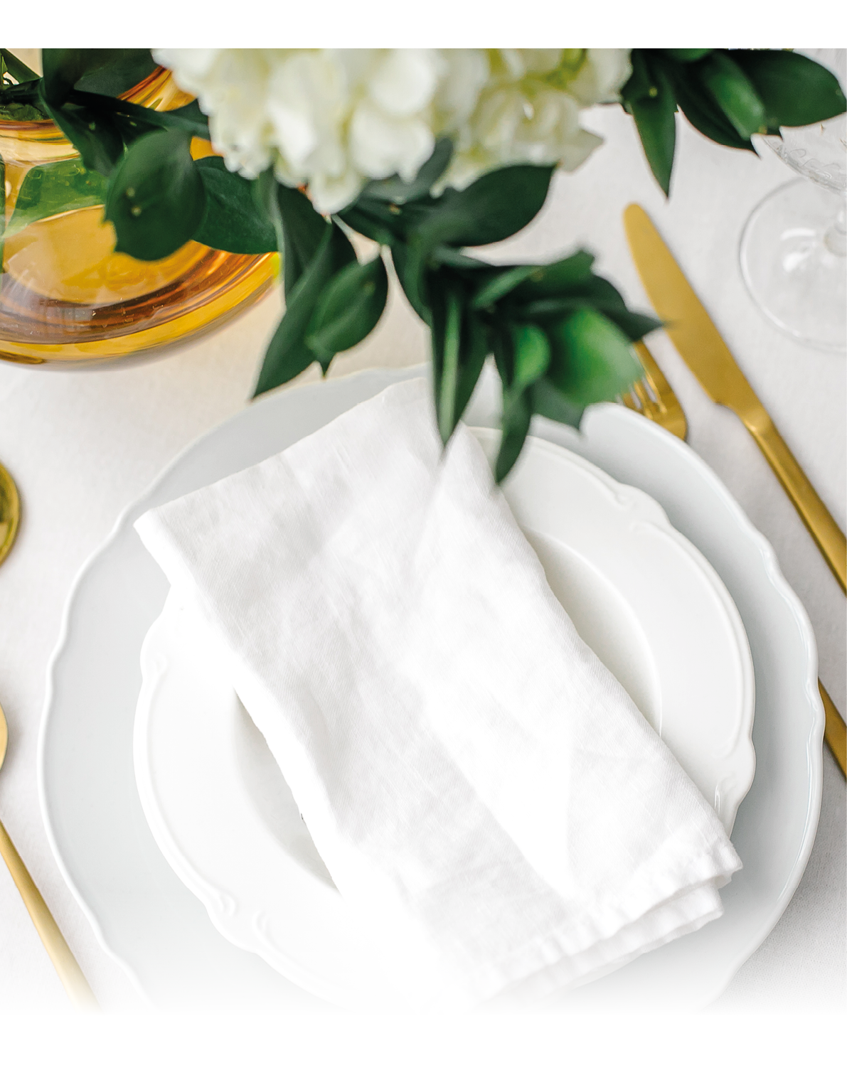 Elegance classic table setting with white dishes, gold cutlery and hydrangea flower. Top view