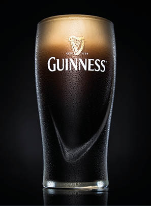EINDHOVEN, THE NETHERLANDS - MAY 18, 2015: Pint of Guinness, the popular Irish beer on a black background. 