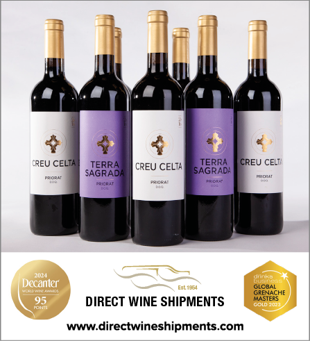 Five bottles of wine are lined up on a table. Description generated by AI