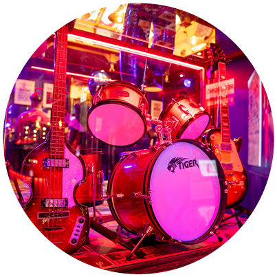 A display case with a guitar, drums, and a bass guitar. Description generated by AI