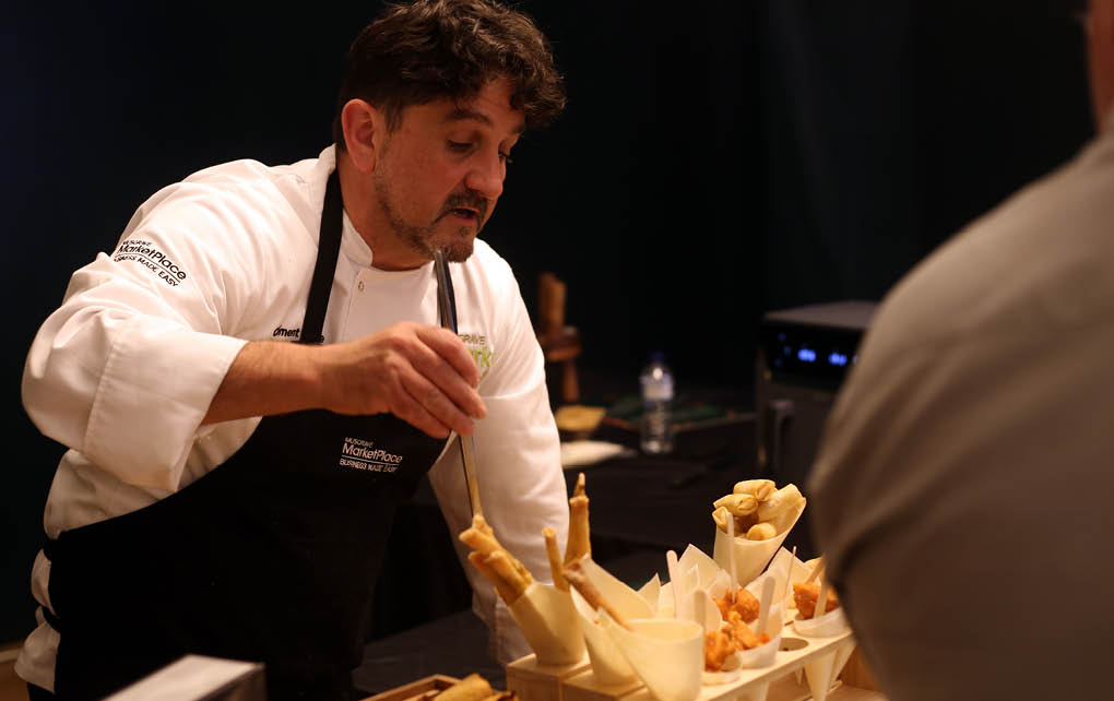 A man in a chef's outfit is preparing food. Description generated by AI