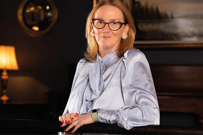 A woman wearing a blue shirt and glasses. Description generated by AI
