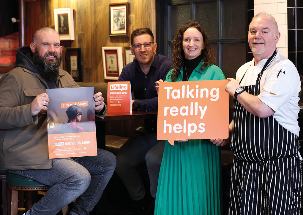 A man holding a sign that says talking really helps. Description generated by AI