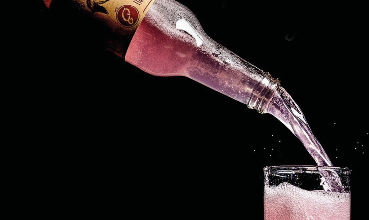 A bottle of wine is pouring into a glass. Description generated by AI