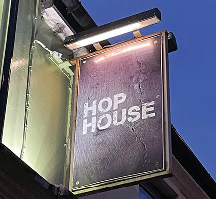 A sign on a building that says “Hop House". Description generated by AI