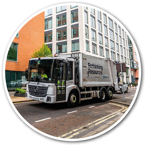 A large white truck is driving down a city street, passing by tall buildings. AI generated content