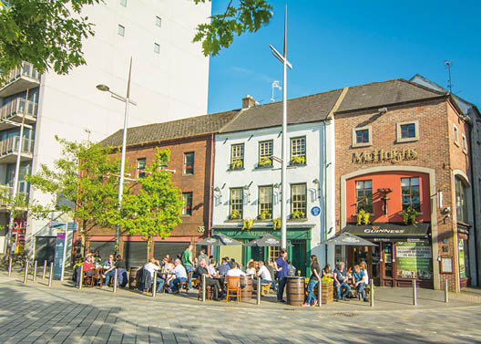 A group of people are sitting outside of a restaurant. Description generated by AI