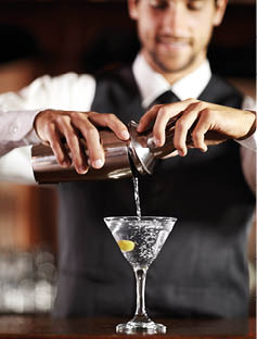 Shaken not stirred. Shot of a handsome young bartender mixing a cocktail.