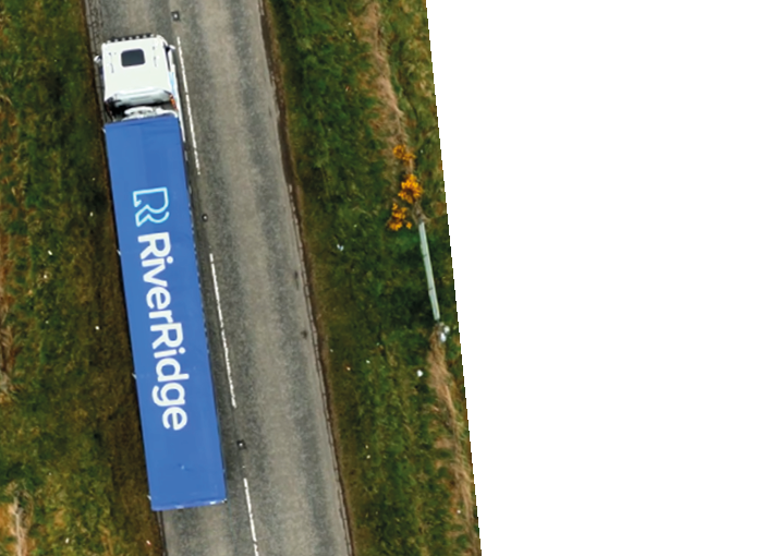 A blue and white truck on a road. Description generated by AI