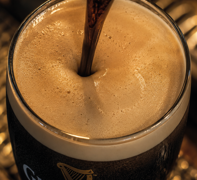 A glass of beer with a straw in it. Description generated by AI