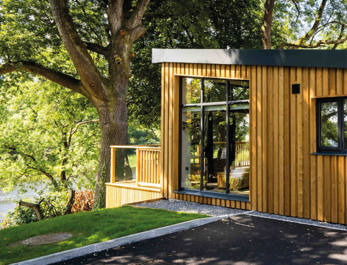 A wooden house with a tree in front of it. Description generated by AI