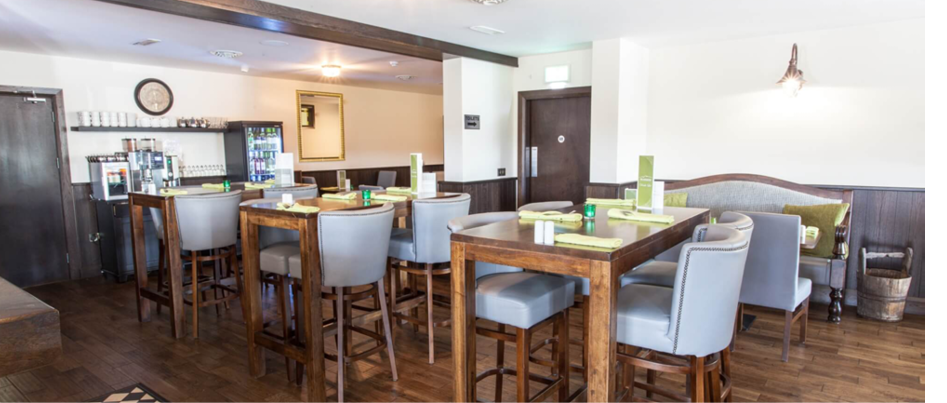 A restaurant with a wooden floor and a bar. Description generated by AI