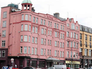 A large pink building with a green roof. Description generated by AI