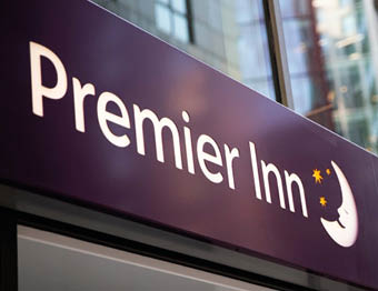 A purple sign with the word “Premier" on it. Description generated by AI