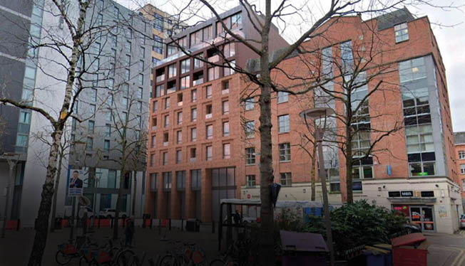 A large brick building with many windows. Description generated by AI