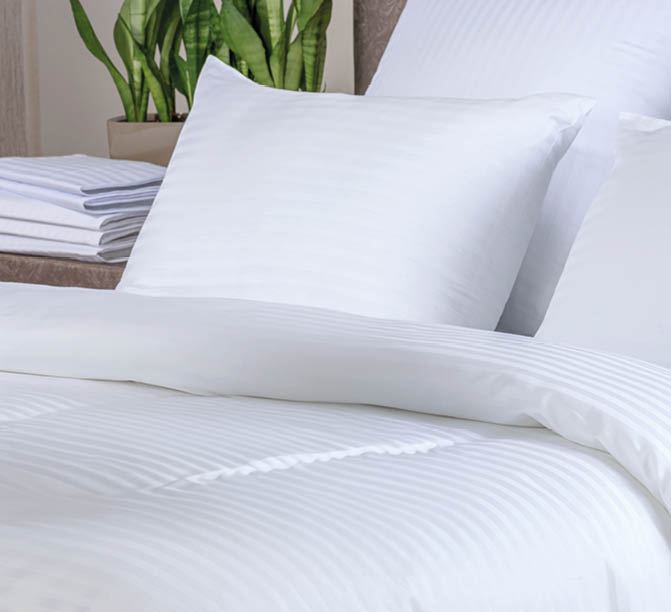 Clean white bath towels on the neatly clean bed of hotel room - coziness and clean concept