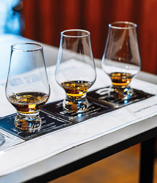 Enjoying whiskey tasting with four glasses and tasting notes on a table