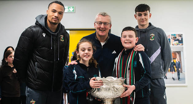 Glentoran players James Douglas and MJ Kamson-Kamara are pictured with P7 pupils Zach and Jorgie and Richard Ewart, Head of Year 7 at Strandtown Primary School, during a visit ahead of the BetMcLean Cup Final.