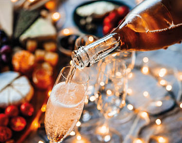 Pouring sparkling wine or champagne served on the table for Christmas or New Year eve celebration.