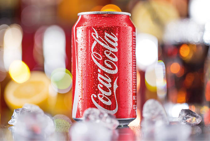 PRAGUE, CZ - APRIL 6, 2015: Can of Coca-Cola on bar desk, close-up. Coca-Cola Company is the leading manufacturer of soda drinks in the world. 