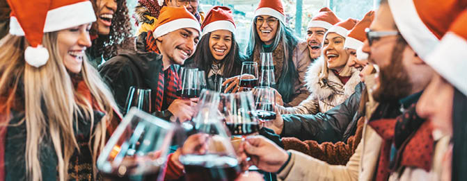 Happy people wearing santa claus hat having Christmas dinner party - Cheerful group of friends celebrating new year together - Winter holidays concept