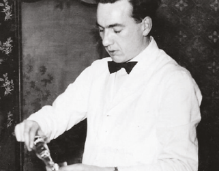 A person wearing a white shirt and black bow tie is pouring a drink into a glass. Description generated by AI