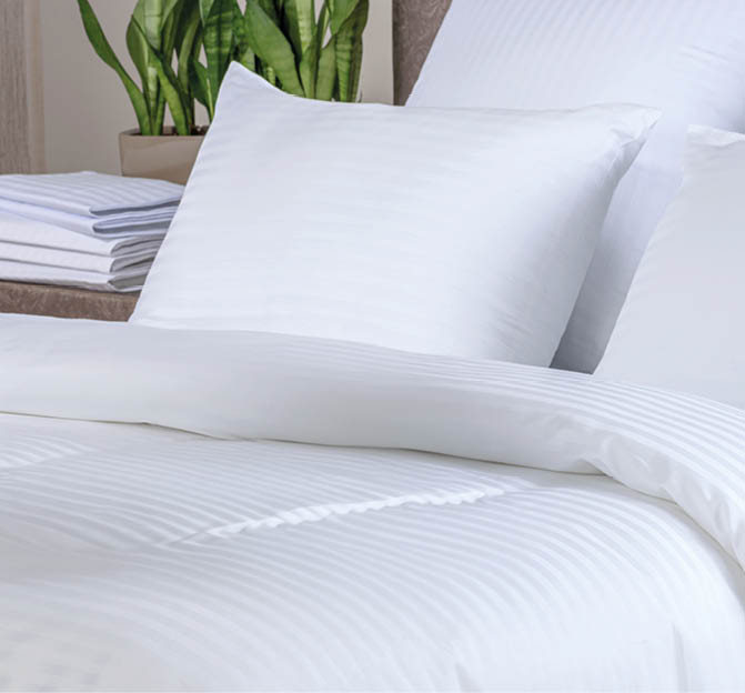 Clean white bath towels on the neatly clean bed of hotel room - coziness and clean concept