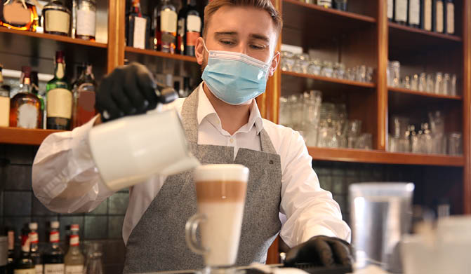 Barista preparing coffee at counter in restaurant. Catering during coronavirus quarantine