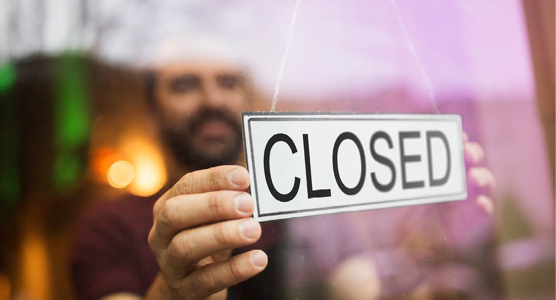 small business, people and crisis concept - owner puts closed sign at bar or restaurant glass door or window