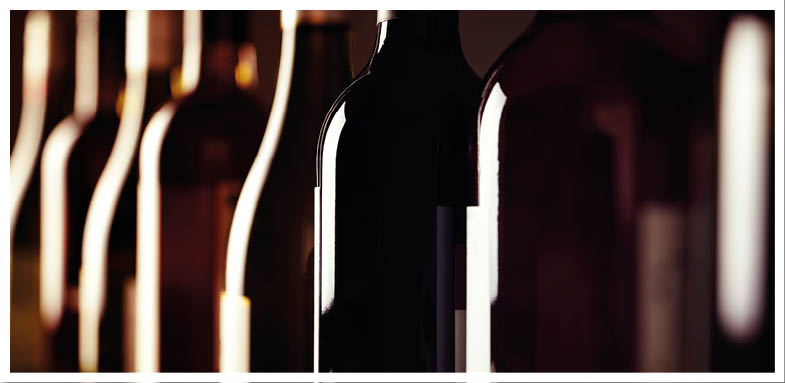 Bottles of old aged wine collection in a row in winery cellar