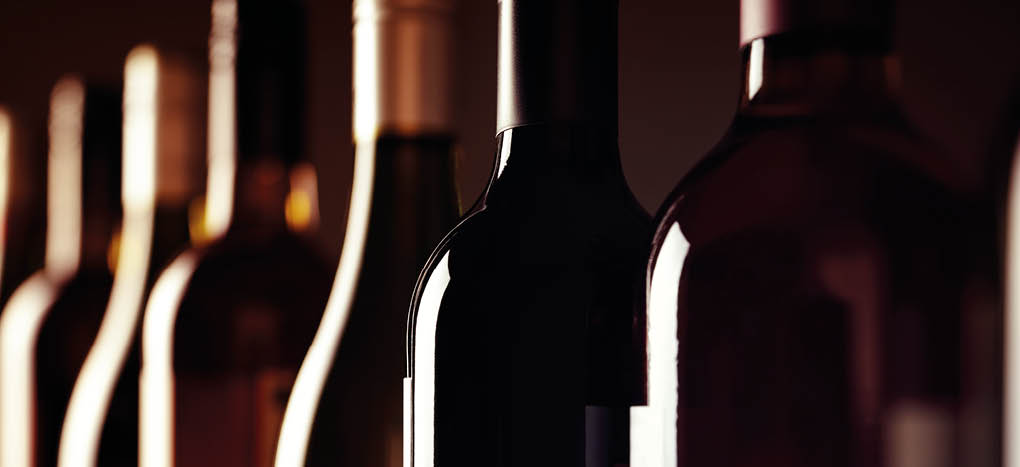 Bottles of old aged wine collection in a row in winery cellar