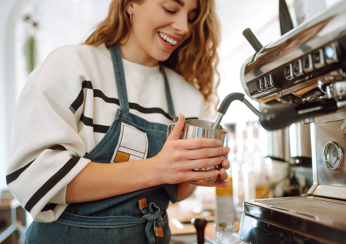 Female barista making coffee in coffee shop counter. Takeaway food.