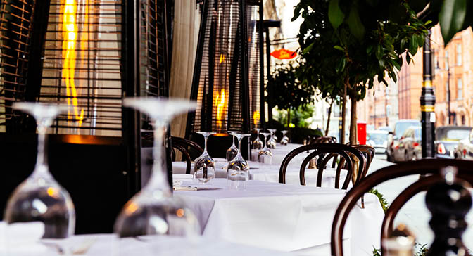 Outdoor luxury restaurant terrace tables and chairs in mayfair London with gas heater pyramid ; Shutterstock ID 613507373; Purchase Order: 8048165; Job Number / Job Name : JN 168849 Calor Patio Heater Cylinders; Client: Calor